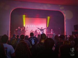 Skerryvore Live Performance Band Skerryvore performs on stage with colorful lights and a crowd watching.